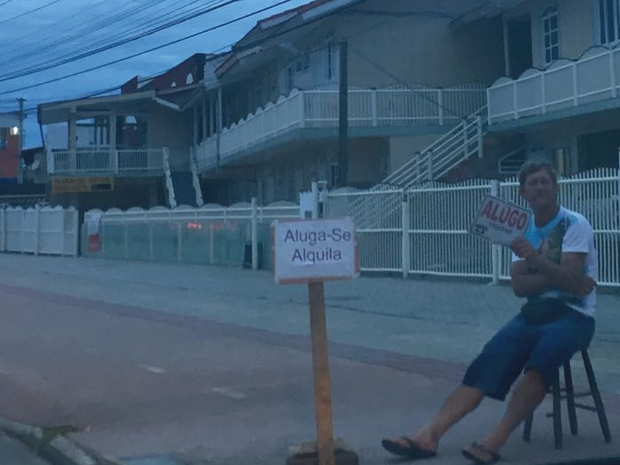 Homem oferece imóvel para aluguel no meio de rua na Praia dos Ingleses, no Norte da ilha (Foto: Anaísa Catucci)